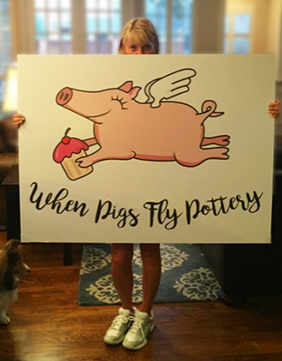 Becki holding When Pigs Fly Pottery poster